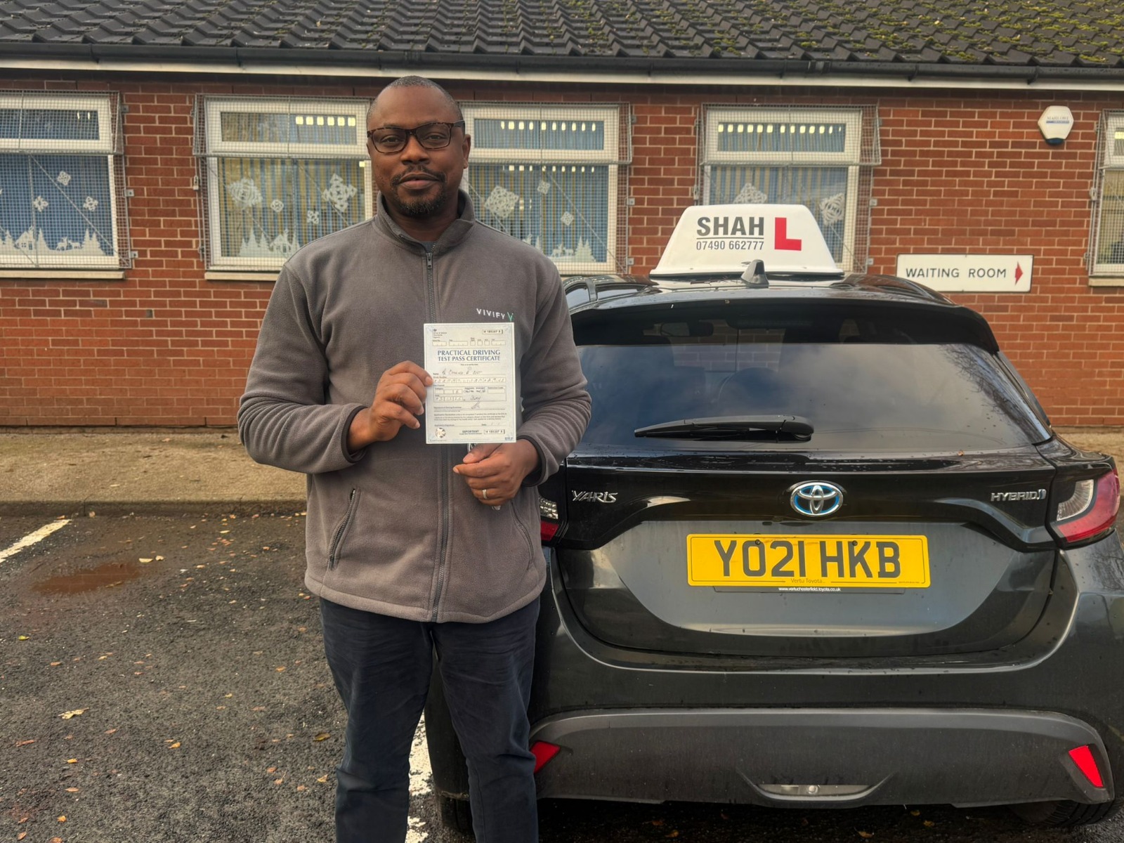 Successful student holding a pass certificate at the Bolton test centre after driving lessons in Bolton.