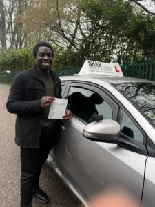Shah Driving School student holding DVSA pass certificate at Bolton Weston Street Test Centre after passing driving lessons in Breightmet BL2"