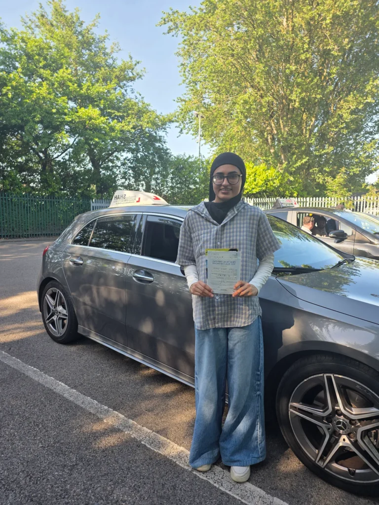 Happy student passing her driving test in Bolton after a crash driving course with Shah Driving School.