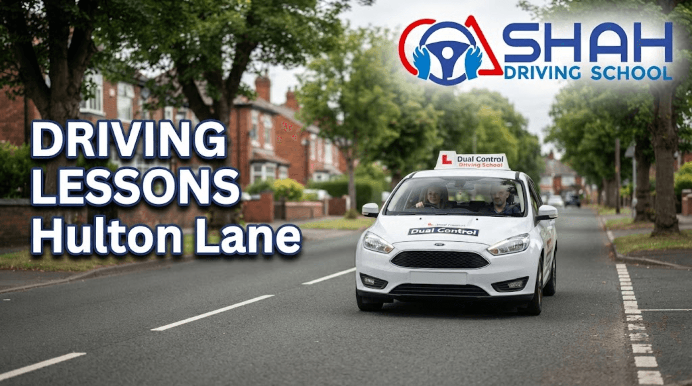 A white dual-control driving tuition car driving down a residential street in Hulton Lane, featuring the Shah Driving School logo and the bold text "Driving Lessons Hulton Lane